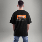 "Black oversized t-shirt featuring a vintage Ford Mustang graphic on the back with an orange grunge background – worn by a male model facing away."