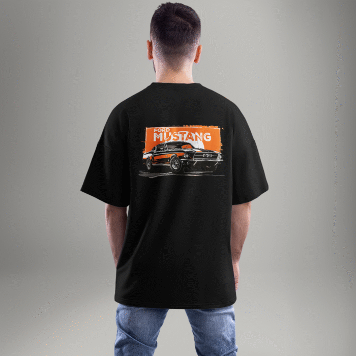 "Black oversized t-shirt featuring a vintage Ford Mustang graphic on the back with an orange grunge background – worn by a male model facing away."