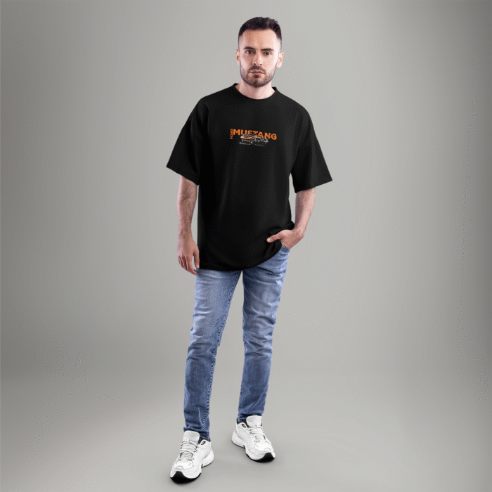Front view of a black oversized t-shirt with a small Ford Mustang logo and classic car graphic on the chest – styled with casual jeans.